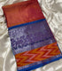 Mangalagiri Pattu red and orange checkered body, a purple floral patterned pallu, and a vibrant orange and red ikat border with a blue edge